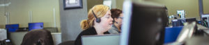 Side View of Woman at desk with headset speaking