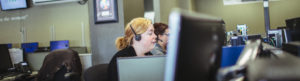 Side View of Woman at desk with headset speaking